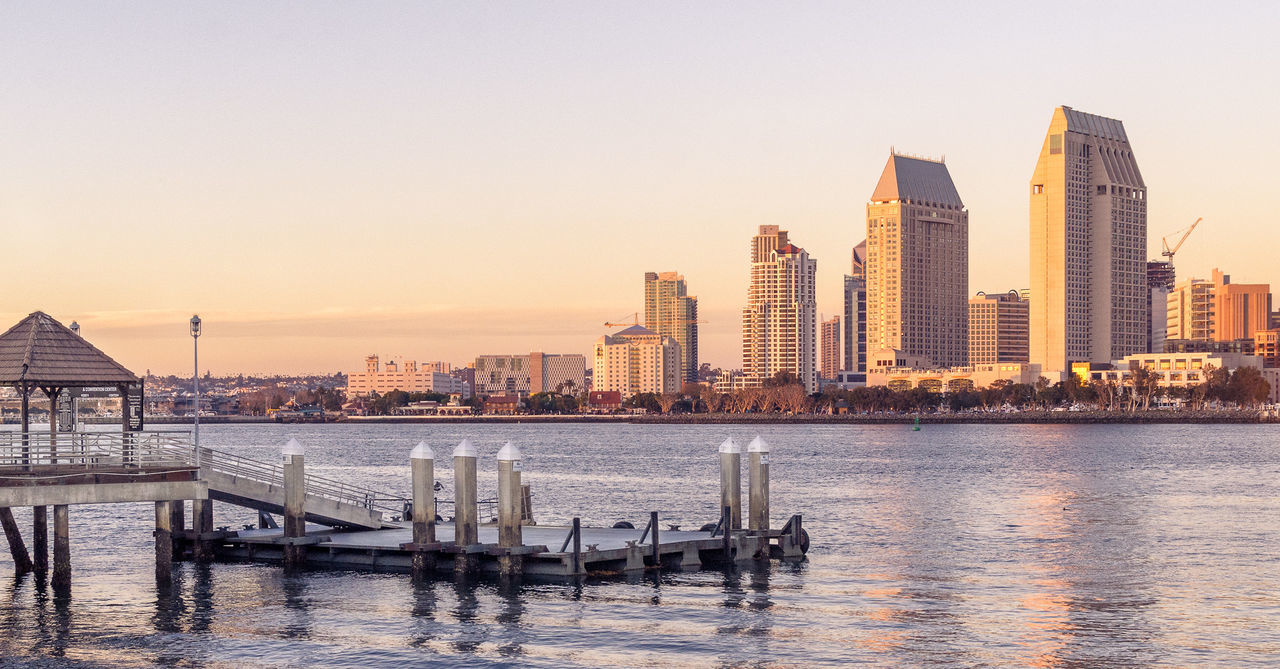 View of city by river at sunset