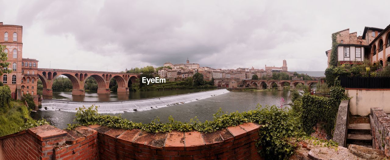 architecture, built structure, building exterior, town, cloud, water, sky, nature, cityscape, city, travel destinations, tourism, landmark, waterway, bridge, history, building, the past, travel, panoramic, river, plant, no people, estate, outdoors, environment, landscape, old, overcast, tree, house, urban area, residential district