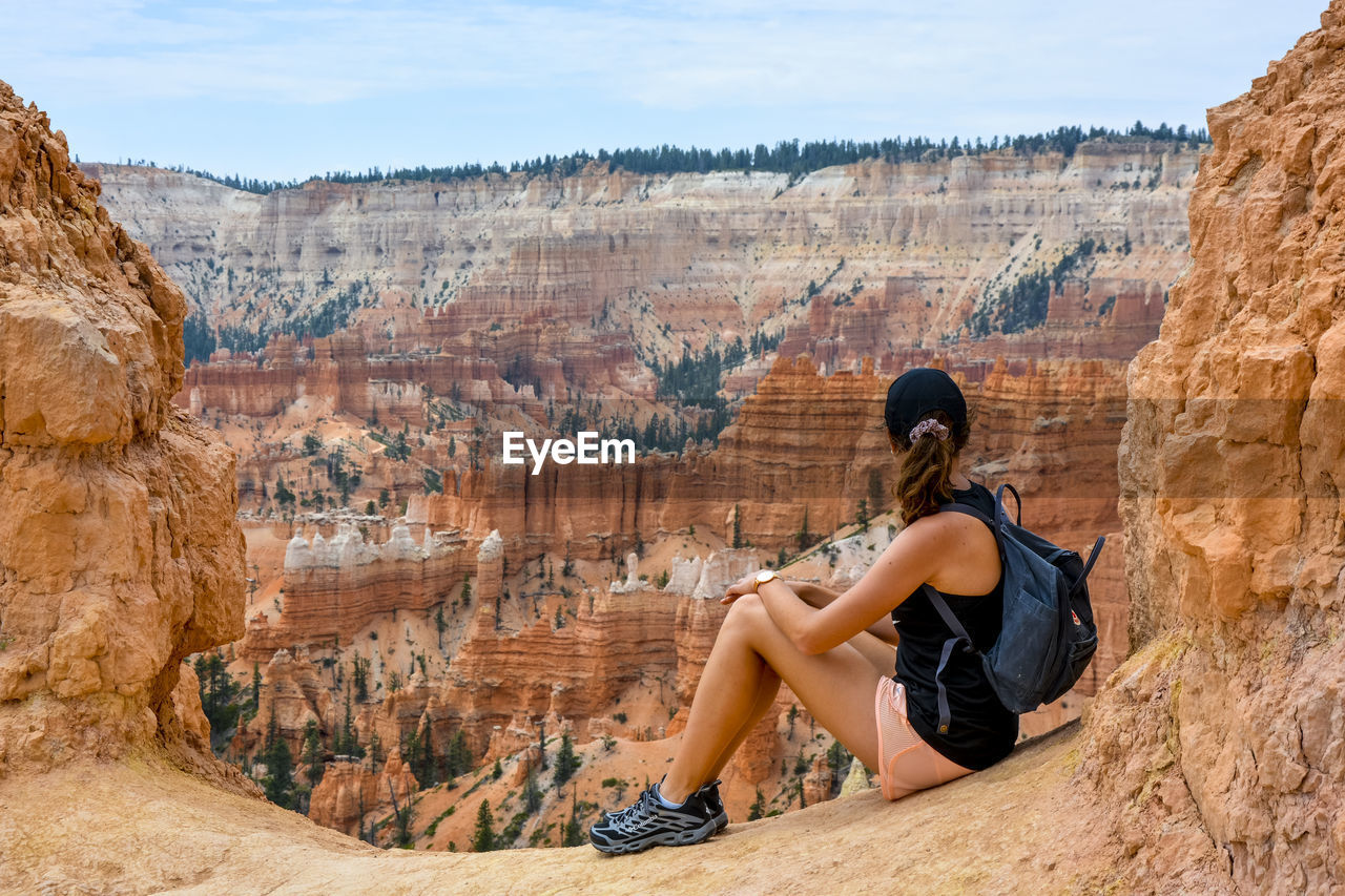 SIDE VIEW OF MAN ON ROCK FORMATION