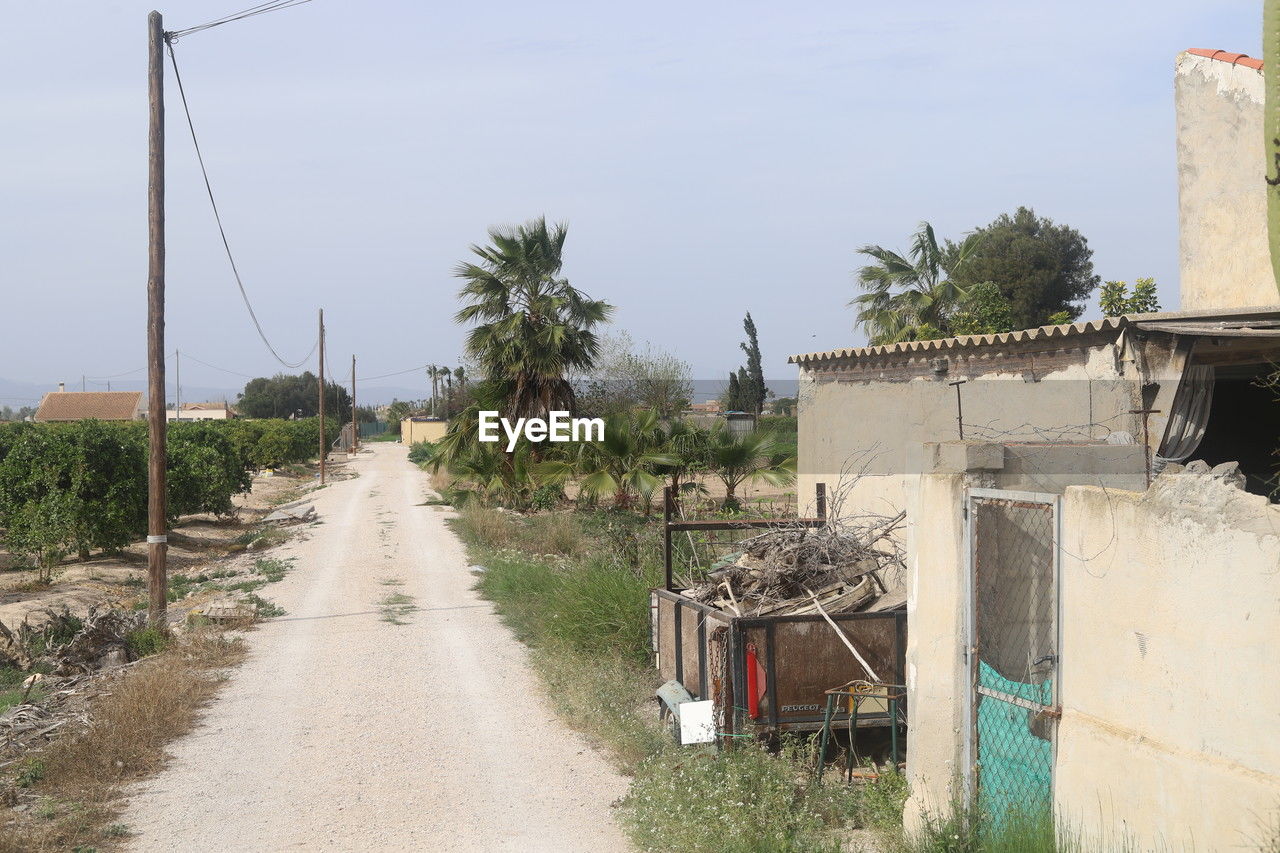 village, plant, architecture, nature, tree, sky, built structure, palm tree, tropical climate, road, no people, building, rural area, building exterior, day, waterway, outdoors, transportation, transport, town, street, water, land, city, house, landscape