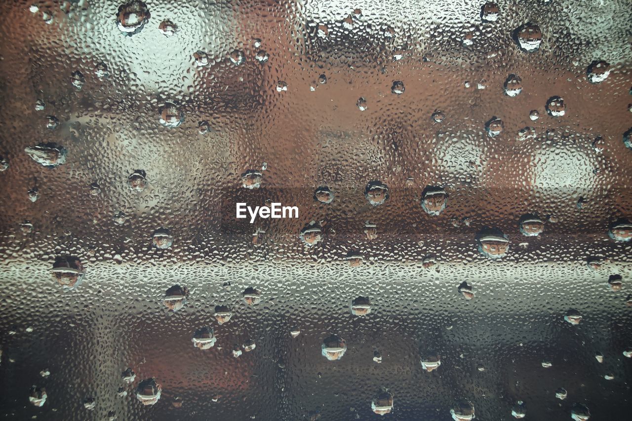 FULL FRAME SHOT OF RAINDROPS ON GLASS