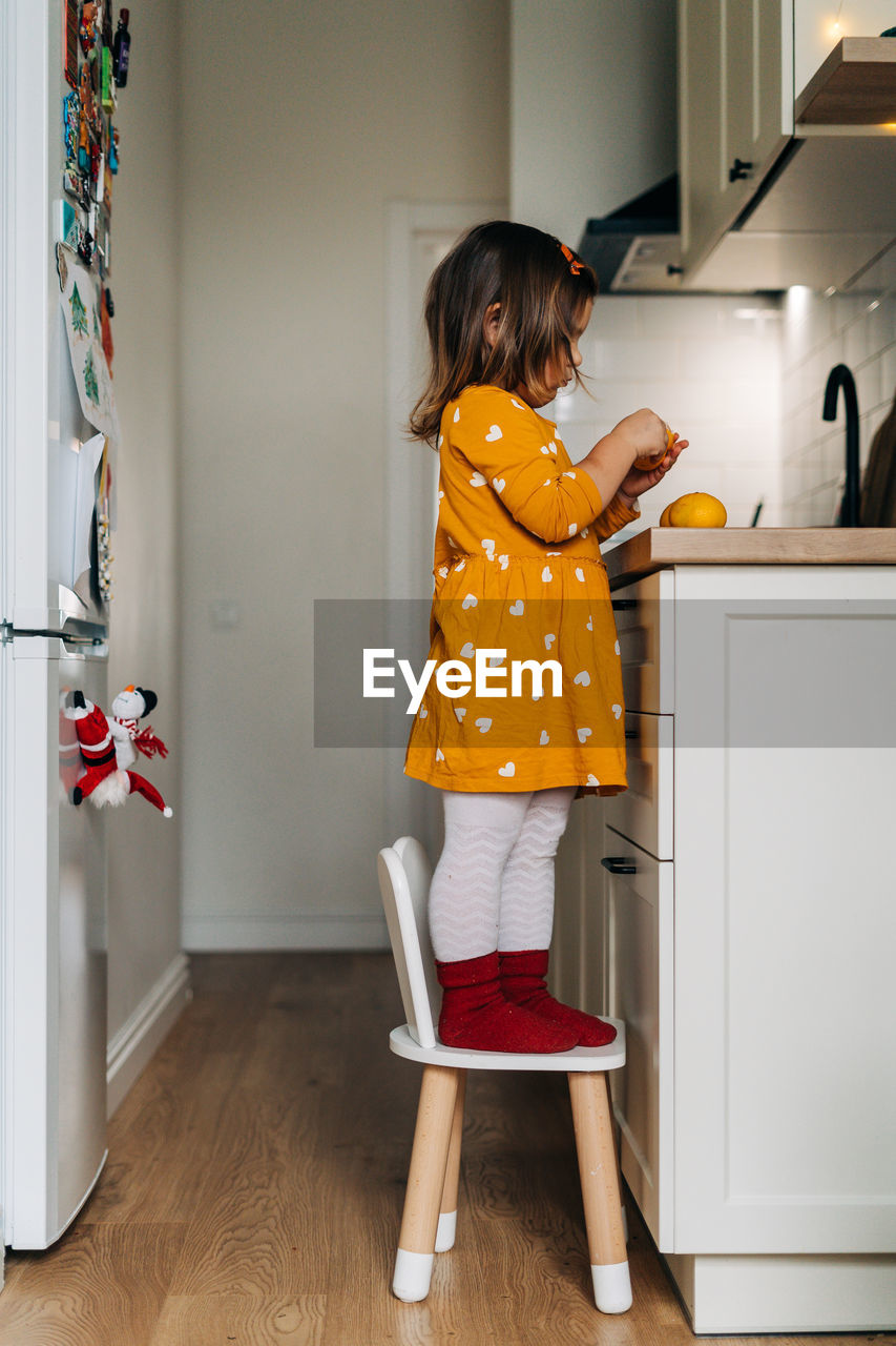 FULL LENGTH OF GIRL STANDING IN THE HOME