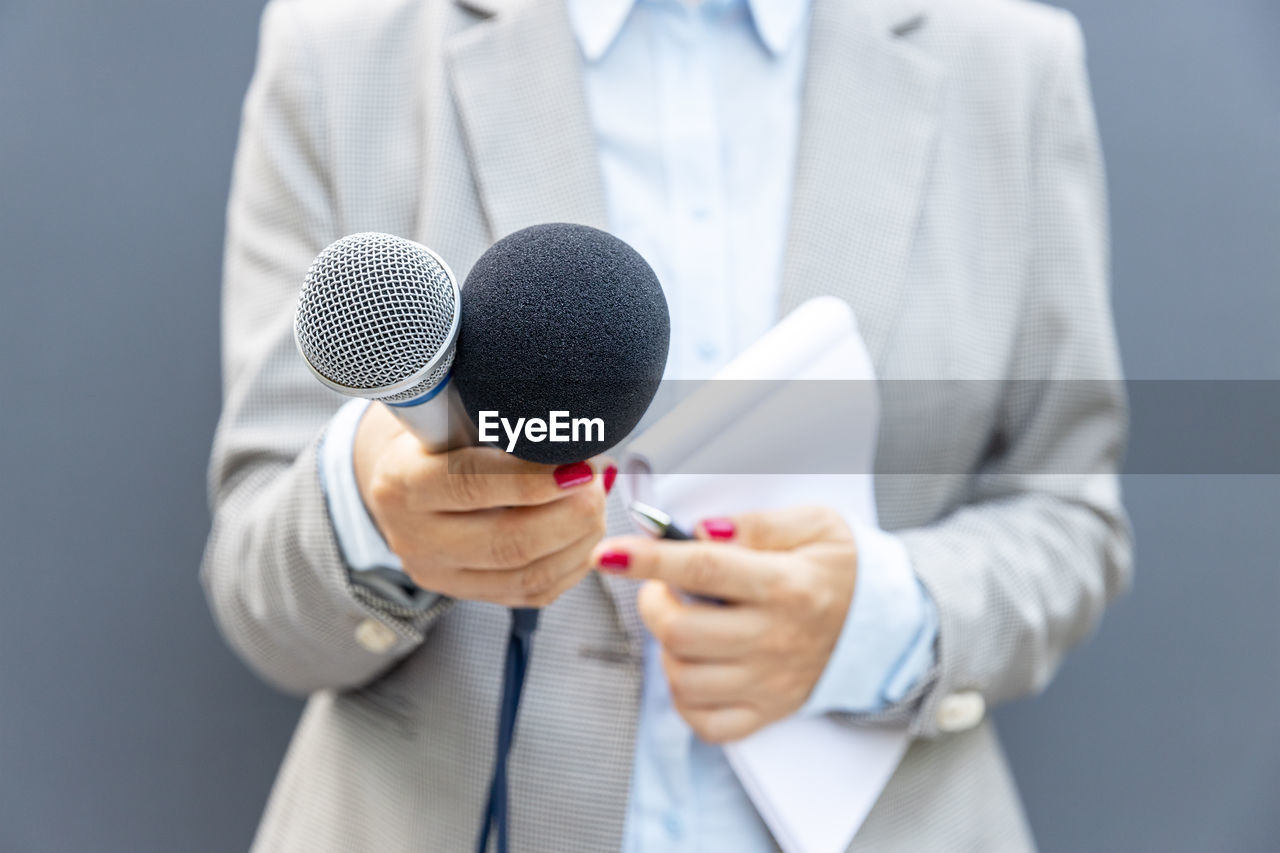 Female reporter holding microphone during media interview. freedom of the press concept.