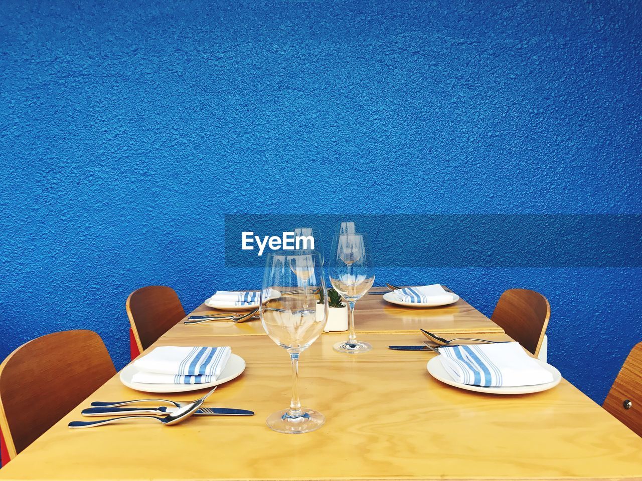 Close-up of dining table against blue wall
