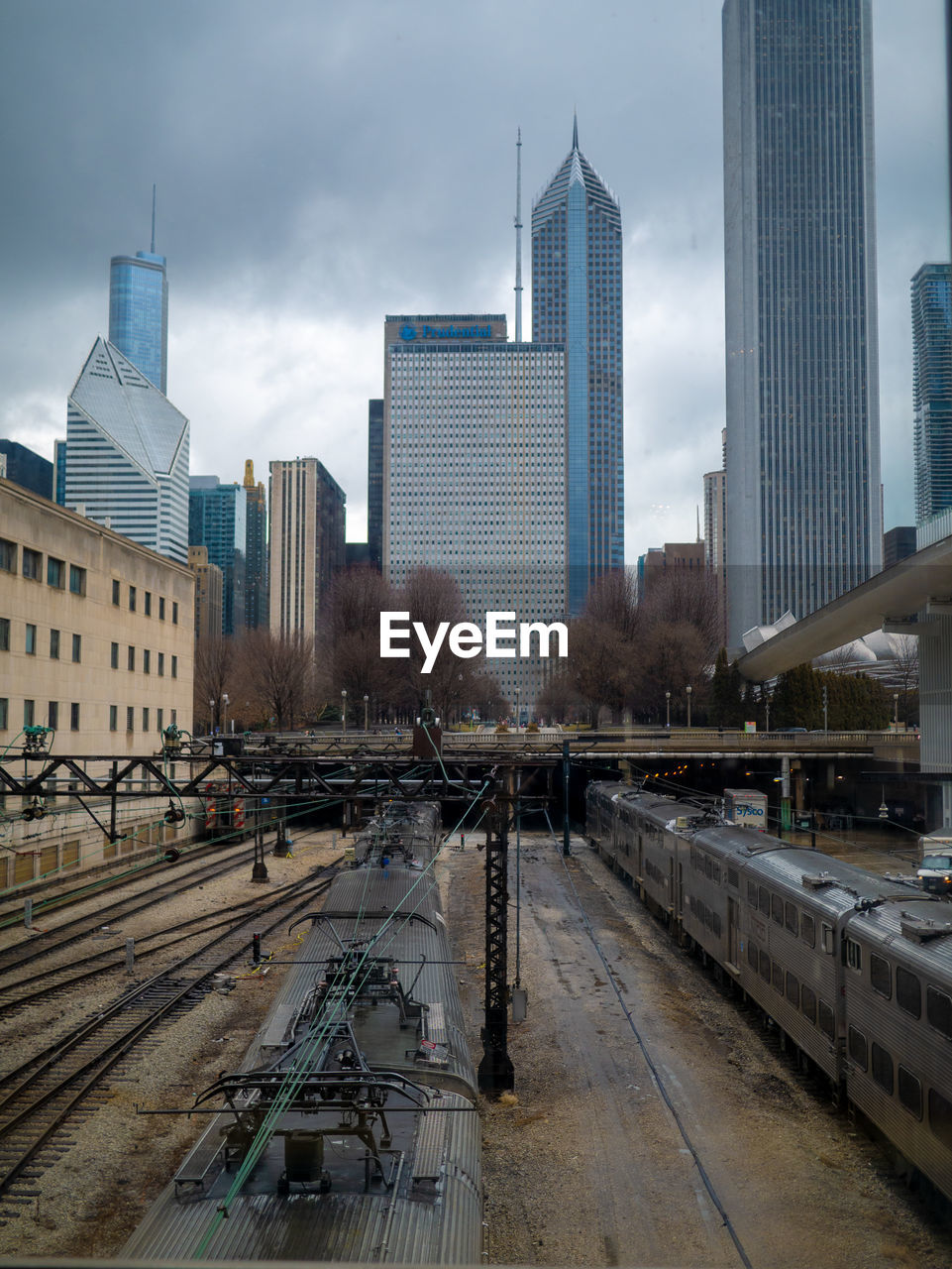 VIEW OF RAILROAD TRACKS AMIDST BUILDINGS IN CITY AGAINST SKY