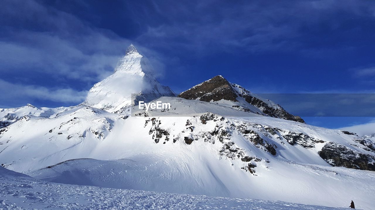 Snow covered mountain against cloudy sky