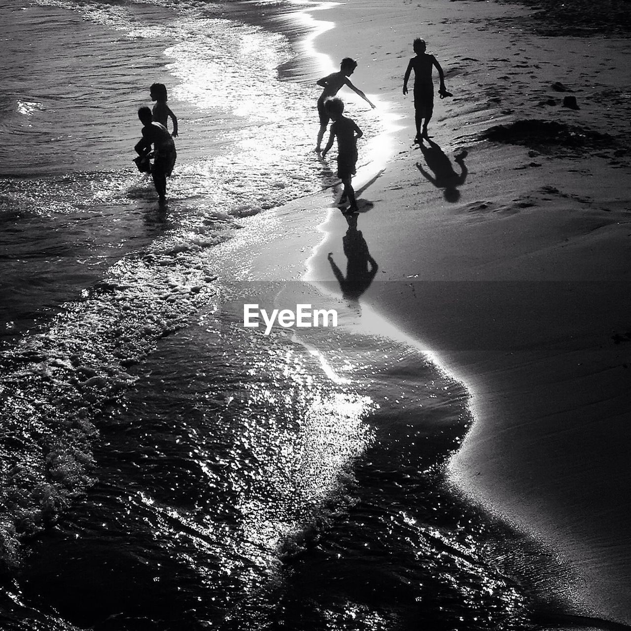 Silhouette children playing on beach