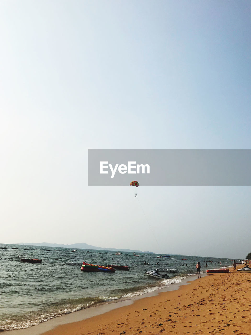 PEOPLE ON BEACH AGAINST CLEAR SKY