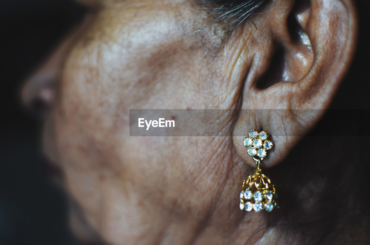 Cropped image of mature woman wearing diamond earring