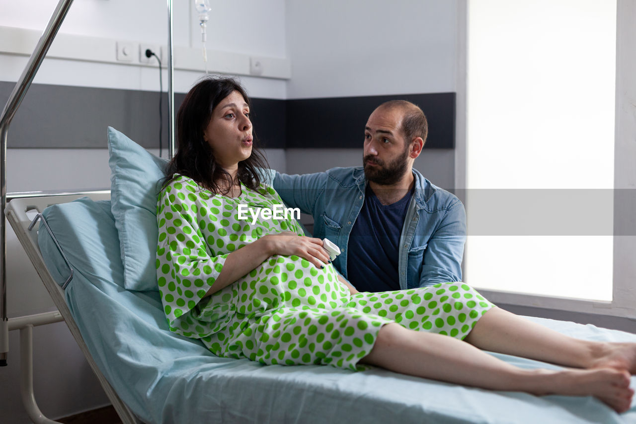 Man with pregnant woman sitting at hospital