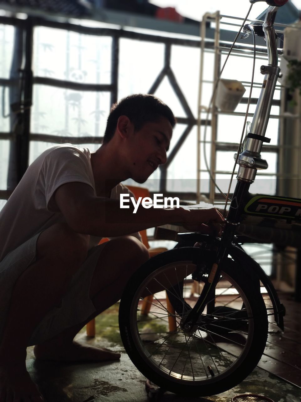 SIDE VIEW OF YOUNG MAN SITTING BICYCLE