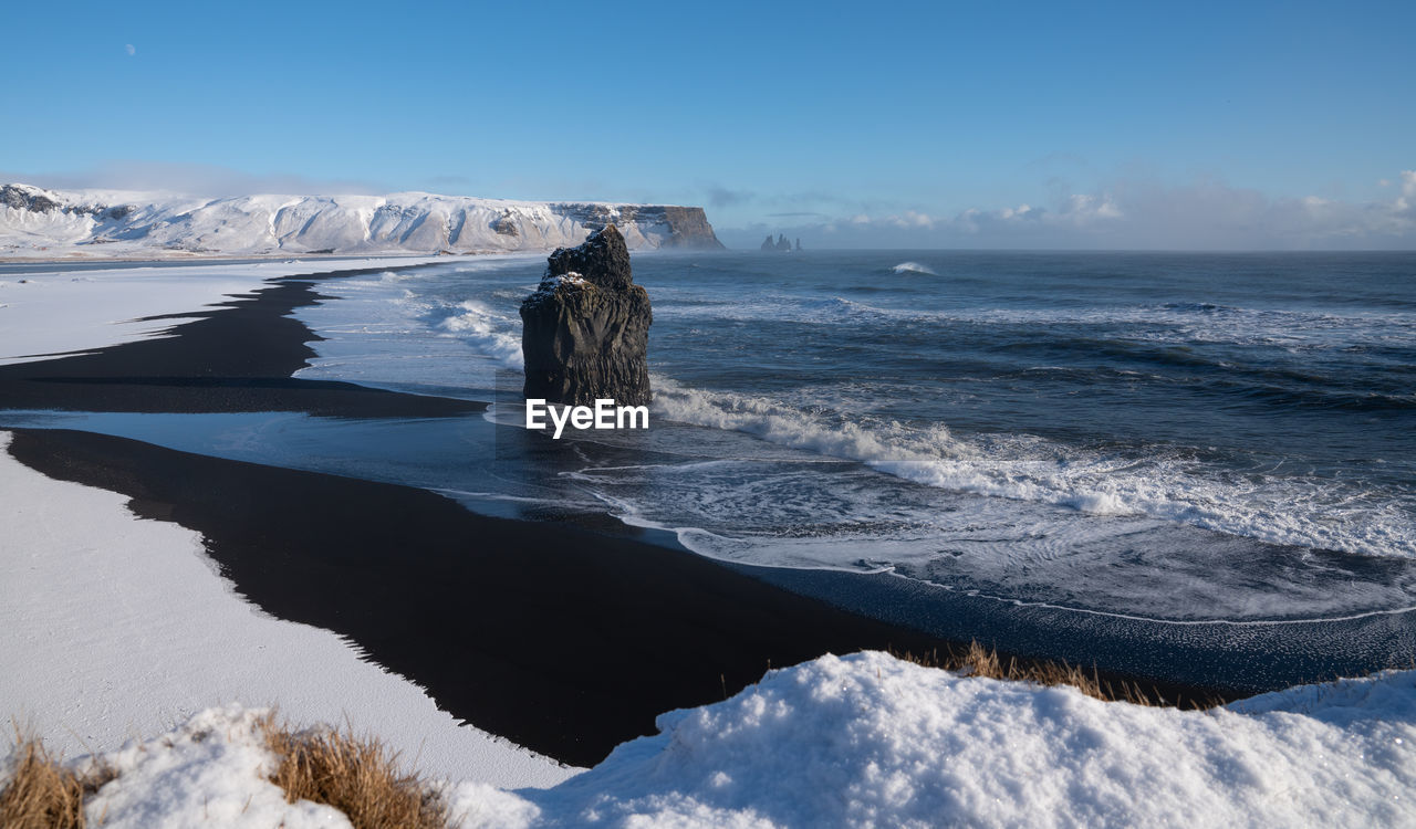 Scenic view of sea against blue sky during winter