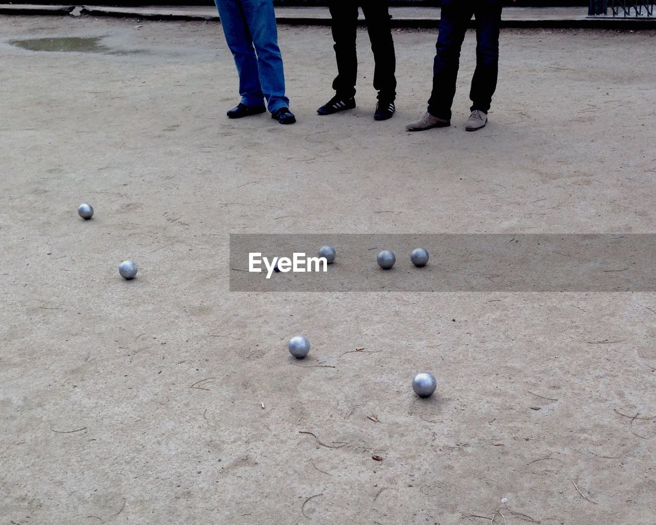 Low section of people playing petanque