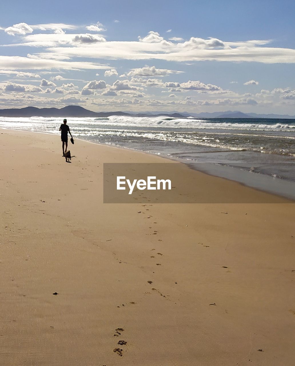 Rear view of child on beach against sky