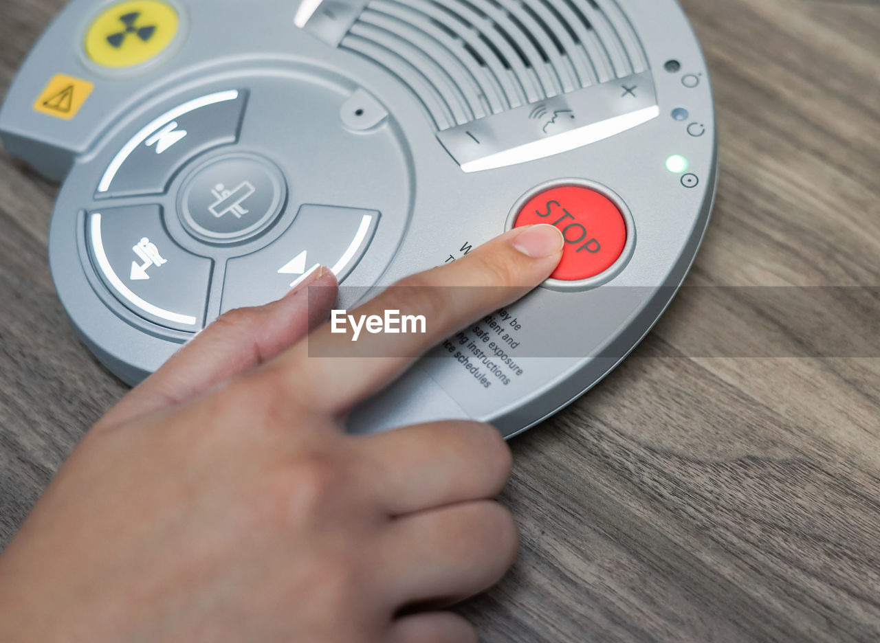 Cropped image of person pressing medical equipment button on table