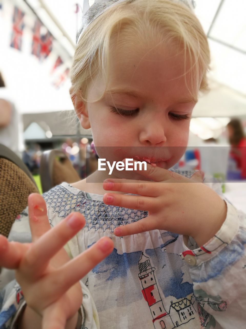 Close-up of girl licking finger