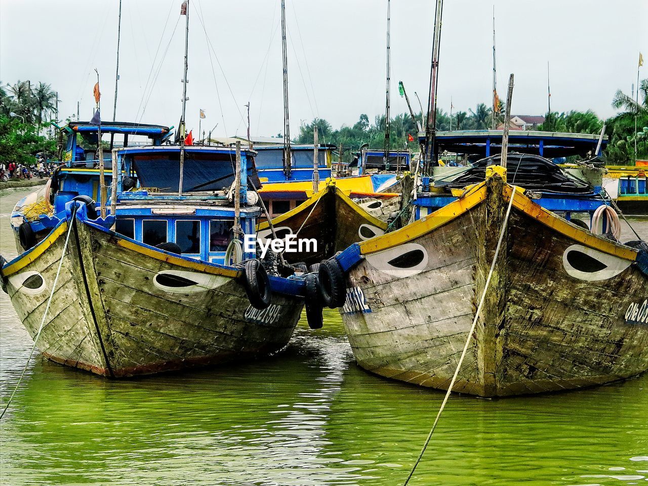 SAILBOATS MOORED IN SEA AGAINST SKY