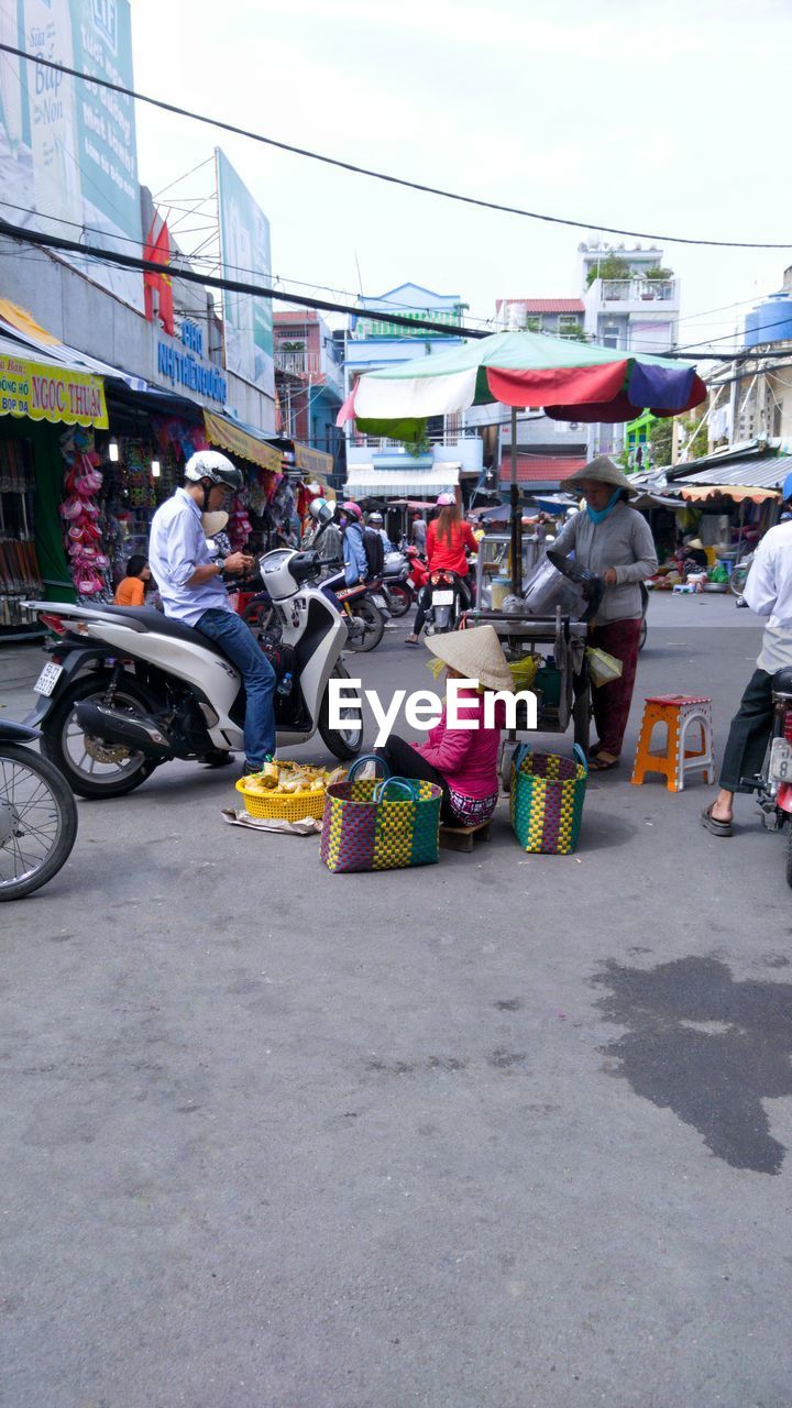 PEOPLE AT MARKET STALL IN CITY