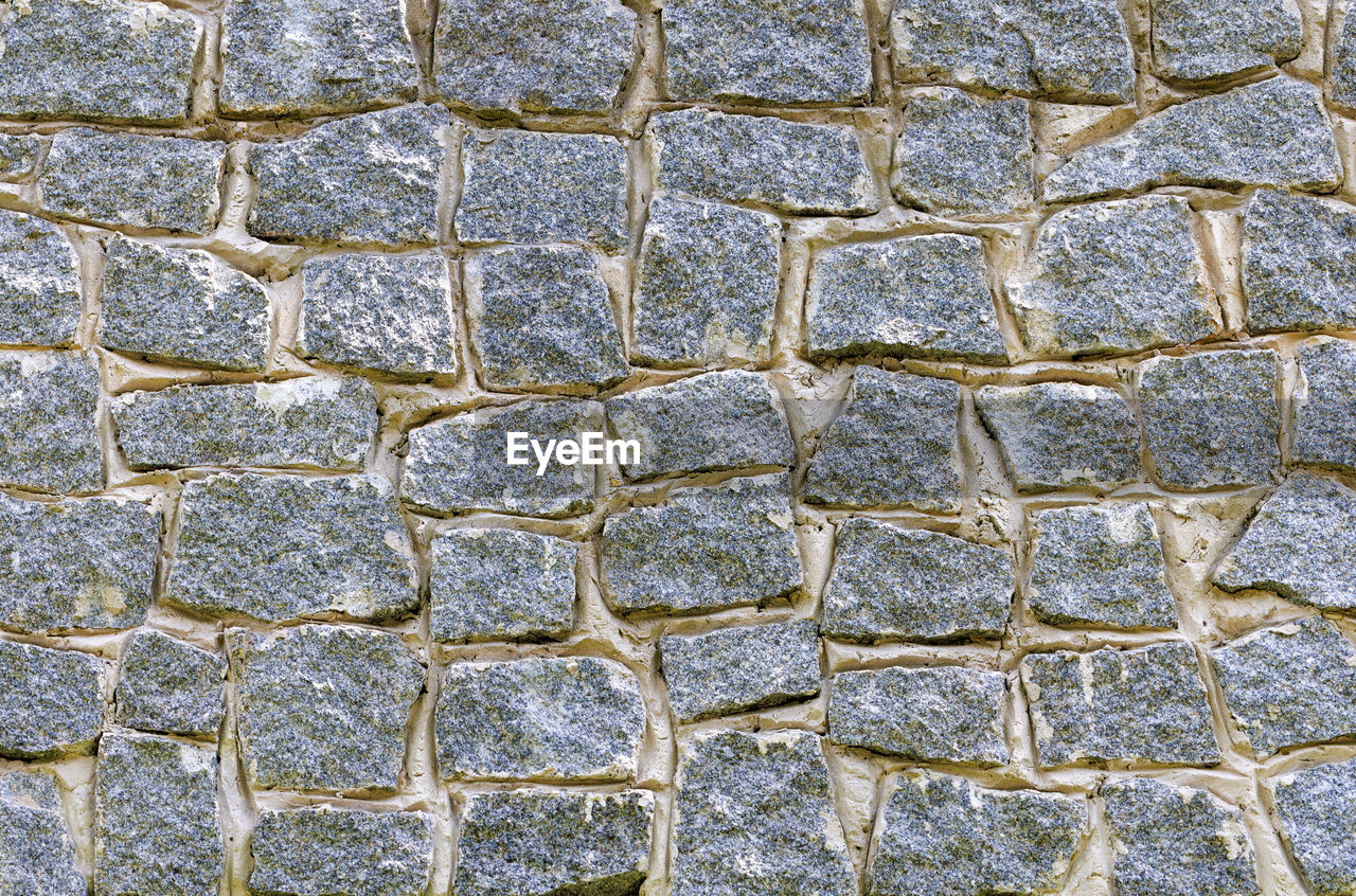 Fragment of a stone wall made of large granite stones.