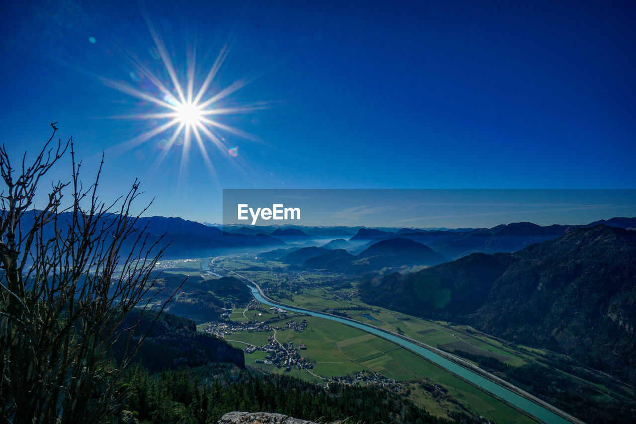 Scenic view of landscape against bright sun