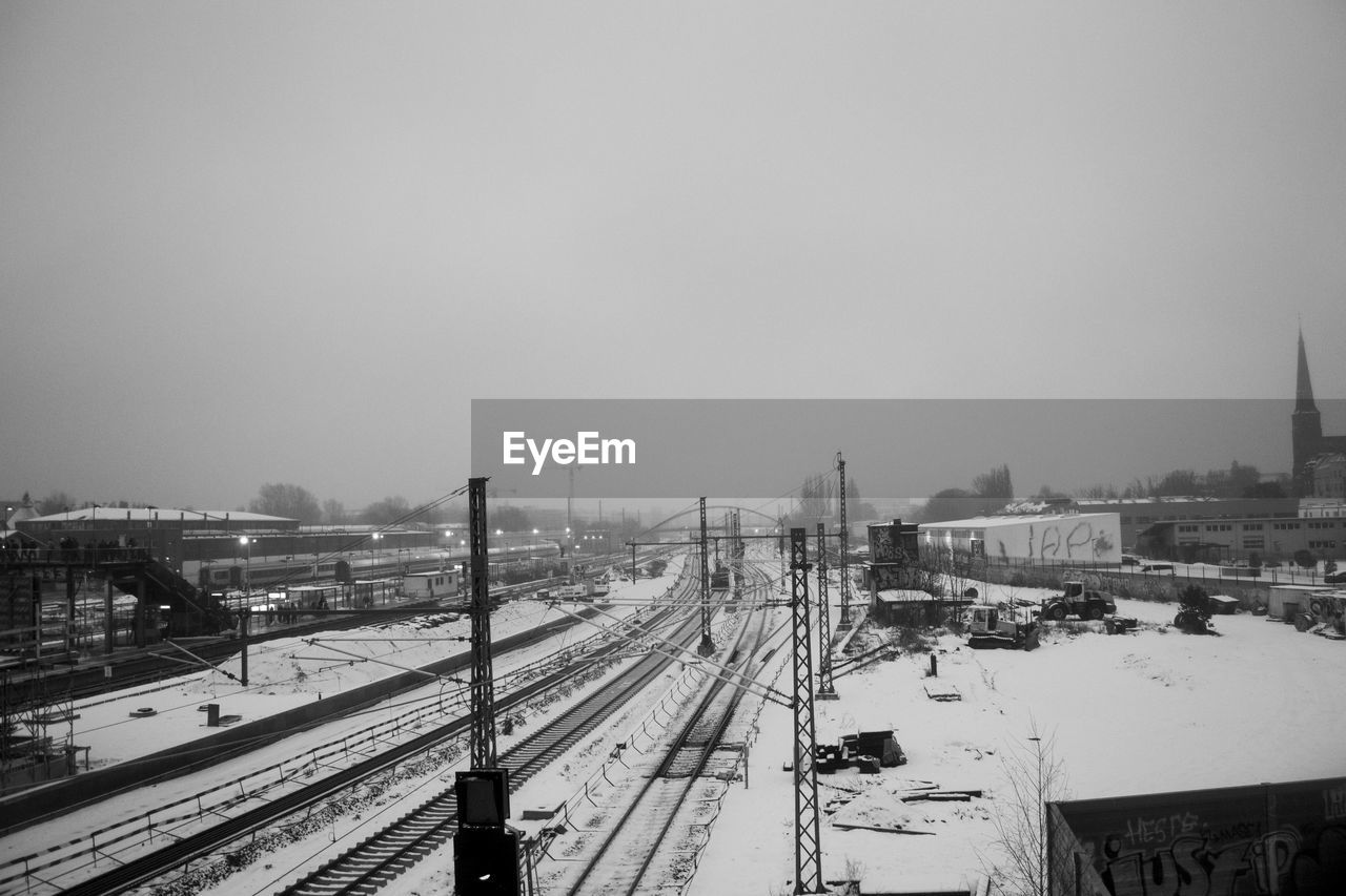 High angle view of snow covered railroad tracks against clear sky