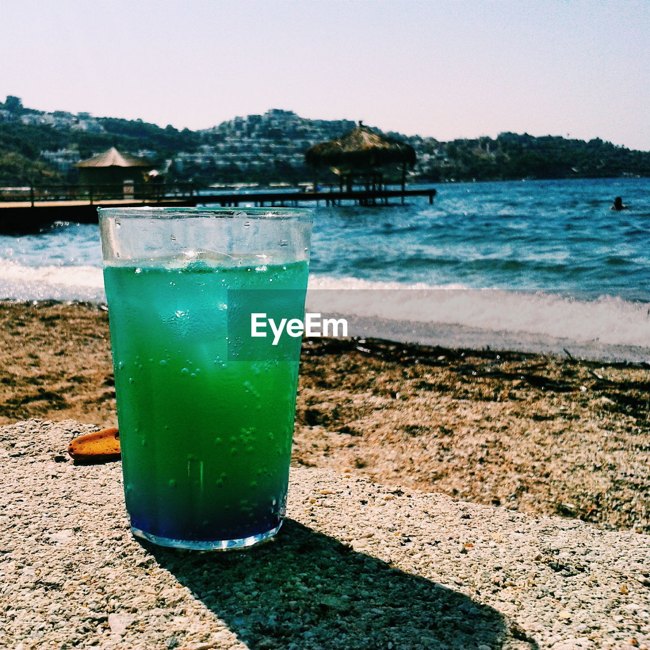 Green cocktail on wall at beach during sunny day