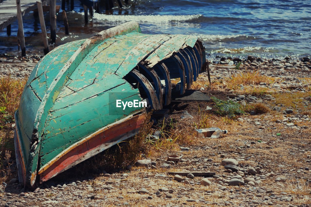 land, beach, vehicle, day, nature, abandoned, water, no people, transportation, transport, sea, outdoors, damaged, nautical vessel, mode of transportation, boat, sand, deterioration, sunlight, metal, decline, old