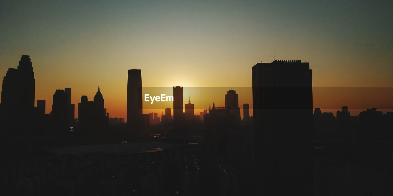 SILHOUETTE CITY BUILDINGS AGAINST SKY DURING SUNSET