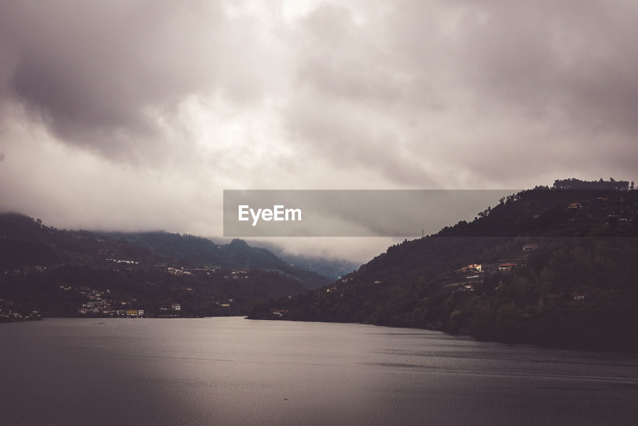 Scenic view of sea and mountains against sky