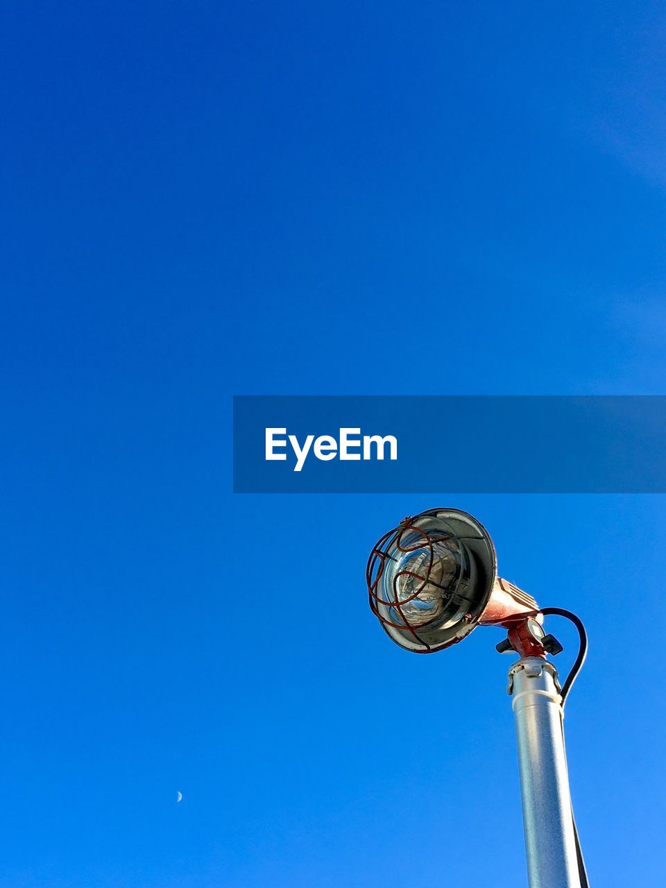 LOW ANGLE VIEW OF ELECTRIC LIGHT AGAINST BLUE SKY