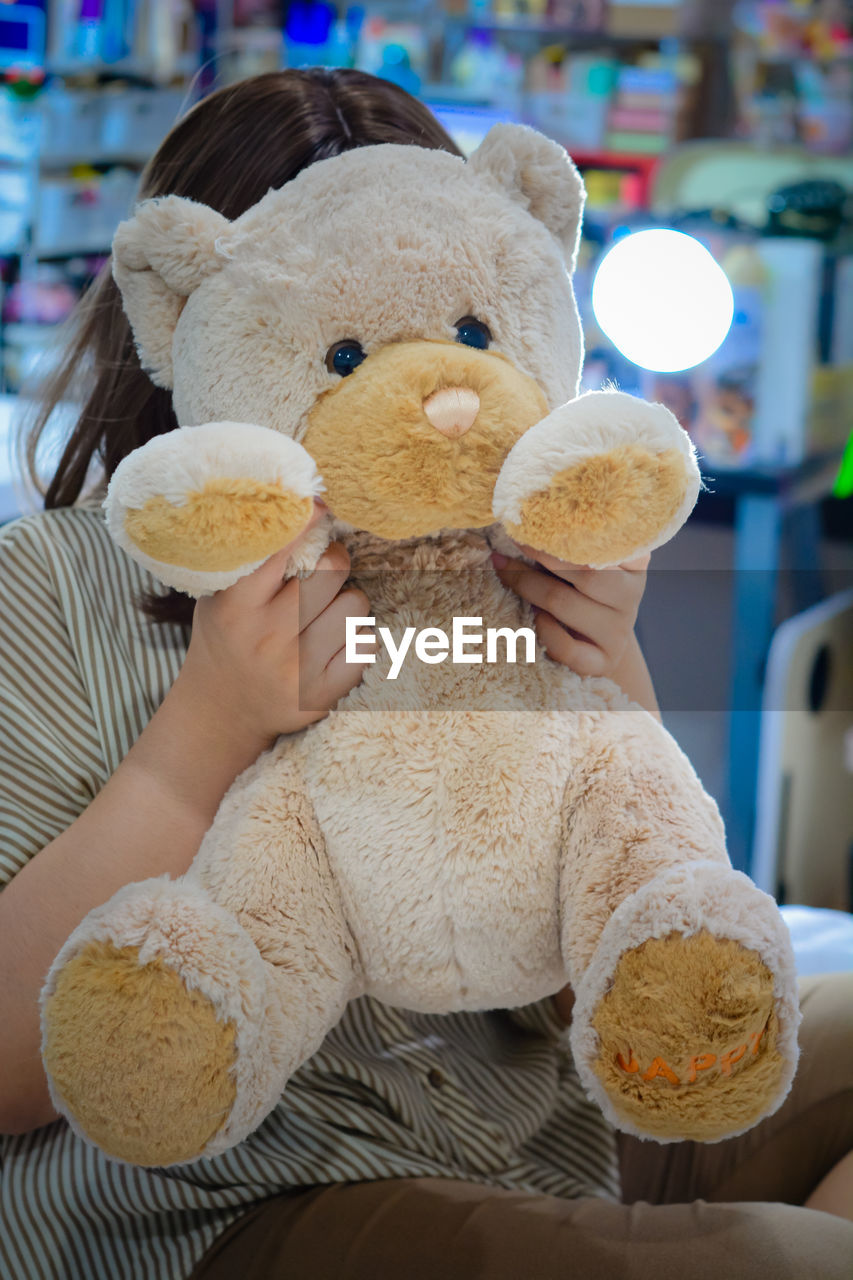 teddy bear, stuffed toy, toy, childhood, indoors, representation, one person, animal representation, textile, sitting, holding, plush, child, focus on foreground, softness, lifestyles