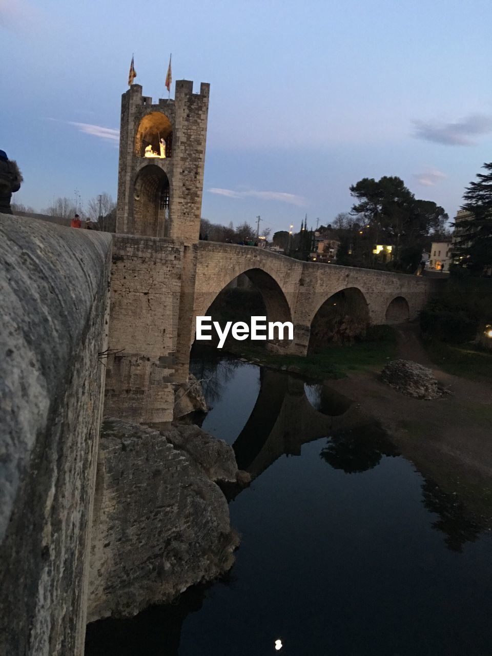 REFLECTION OF A CLOCK TOWER ON WATER