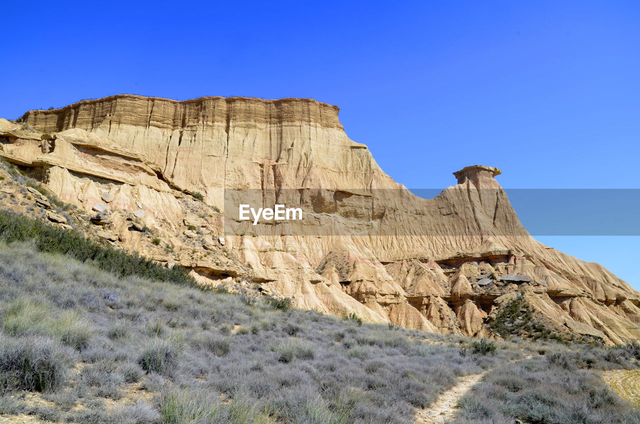 LOW ANGLE VIEW OF ROCK FORMATIONS AGAINST CLEAR SKY
