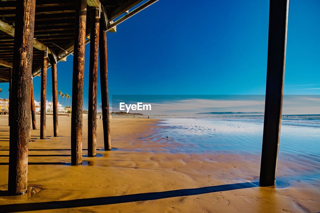 SCENIC VIEW OF SEA AGAINST CLEAR BLUE SKY SEEN THROUGH PIER
