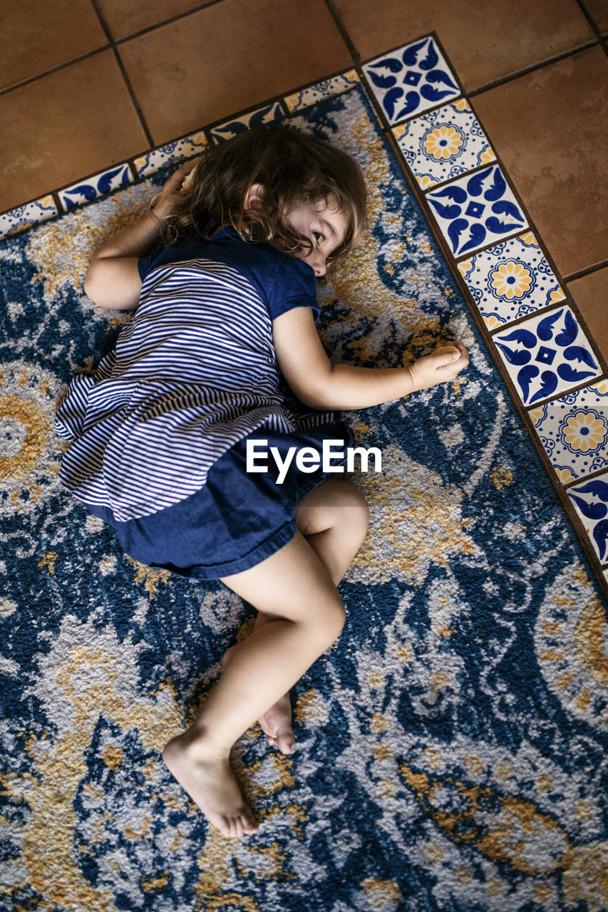 High angle view of girl lying on carpet