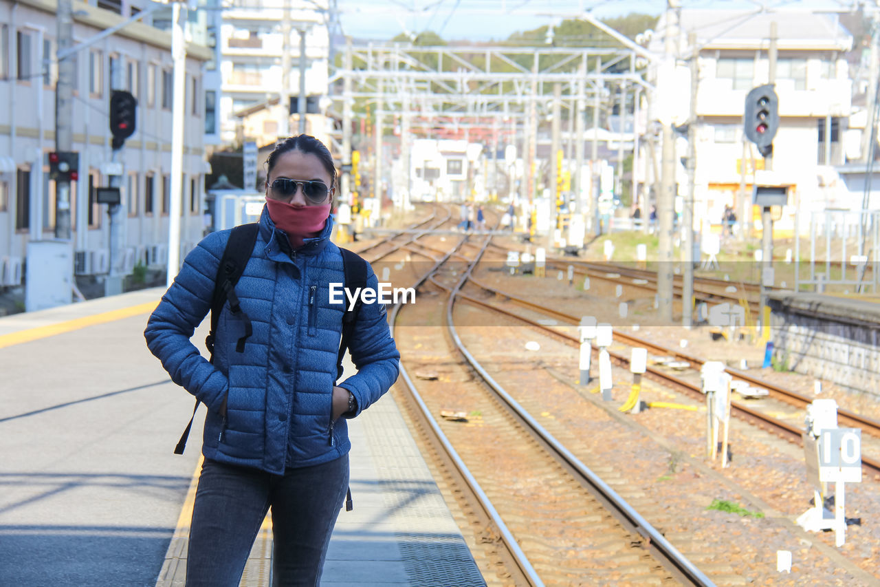 Portrait of young man standing on railroad station