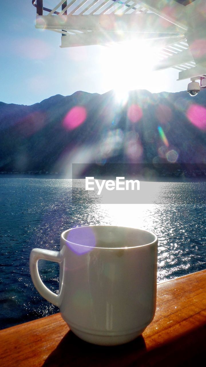 refreshment, drink, lens flare, food and drink, table, mountain, no people, close-up, sunlight, water, day, indoors, freshness, nature, tea - hot drink, sky