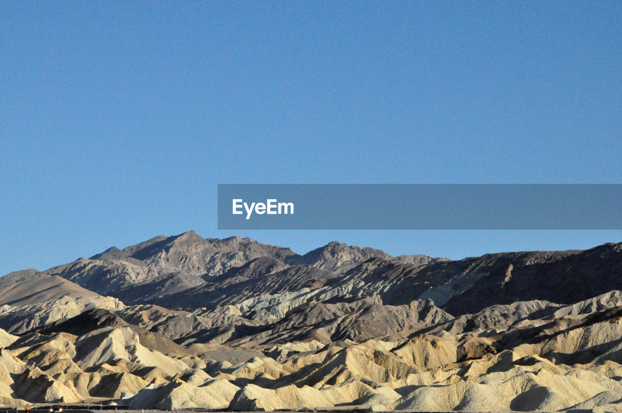 Scenic view of mountains against clear blue sky