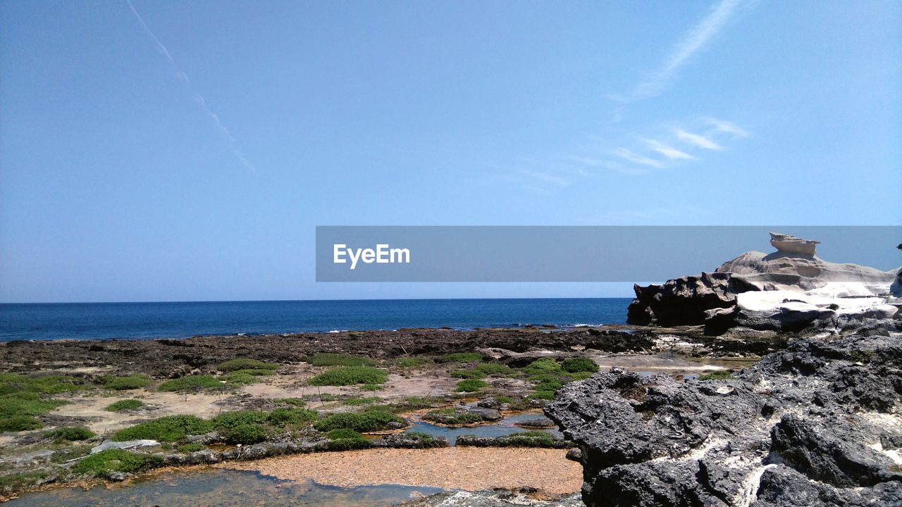 Scenic view of sea against clear blue sky