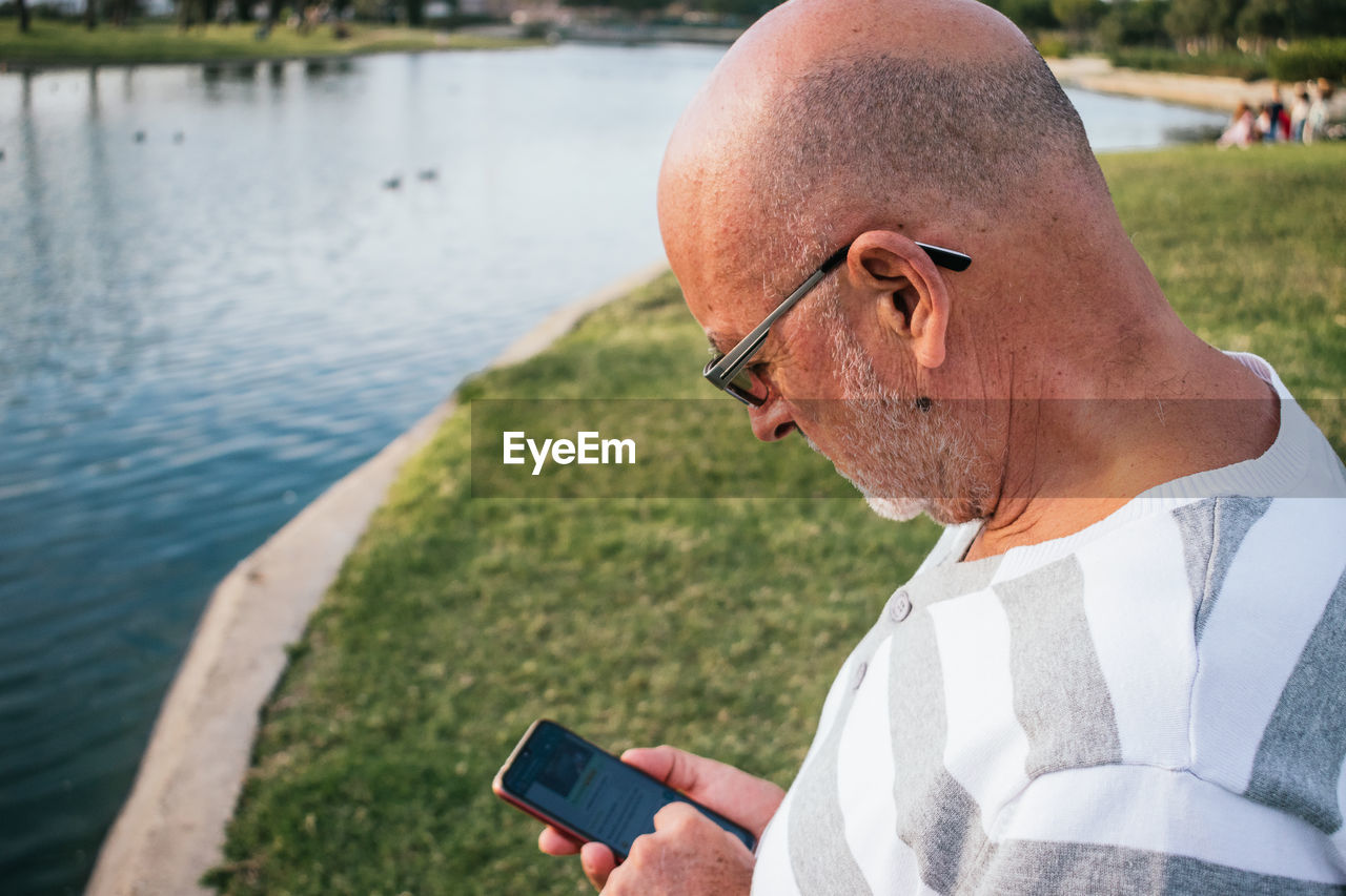 Retired man looking at his smartphone