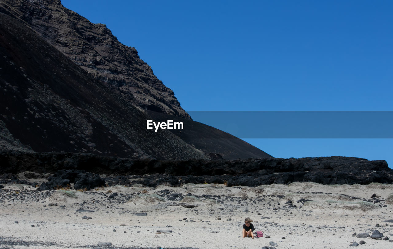 Scenic view of mountain against clear blue sky near from a beach. 