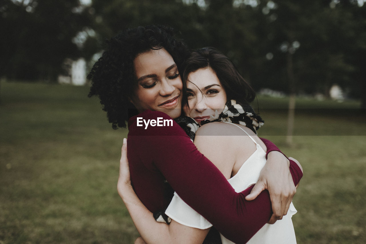 Female friends embracing at park