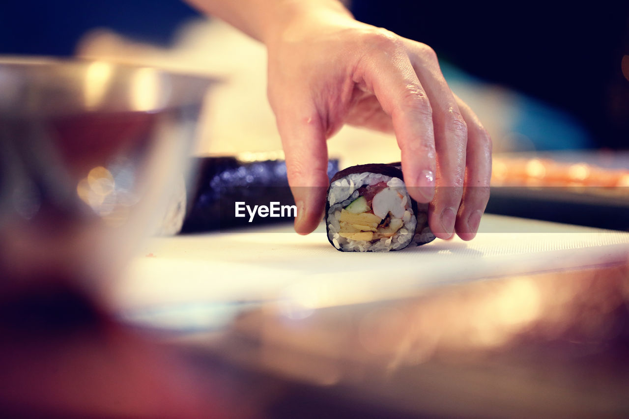 Cropped image of chef preparing sushi in restaurant