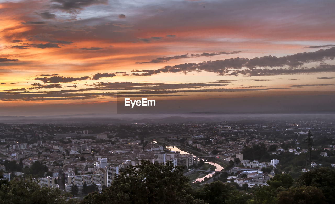 HIGH ANGLE SHOT OF TOWNSCAPE AGAINST SKY DURING SUNSET