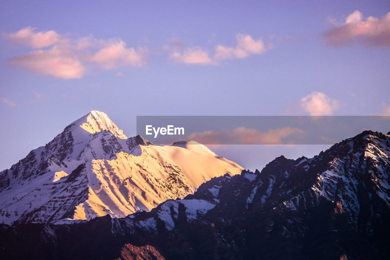 Scenic view of snowcapped mountains against blue sky