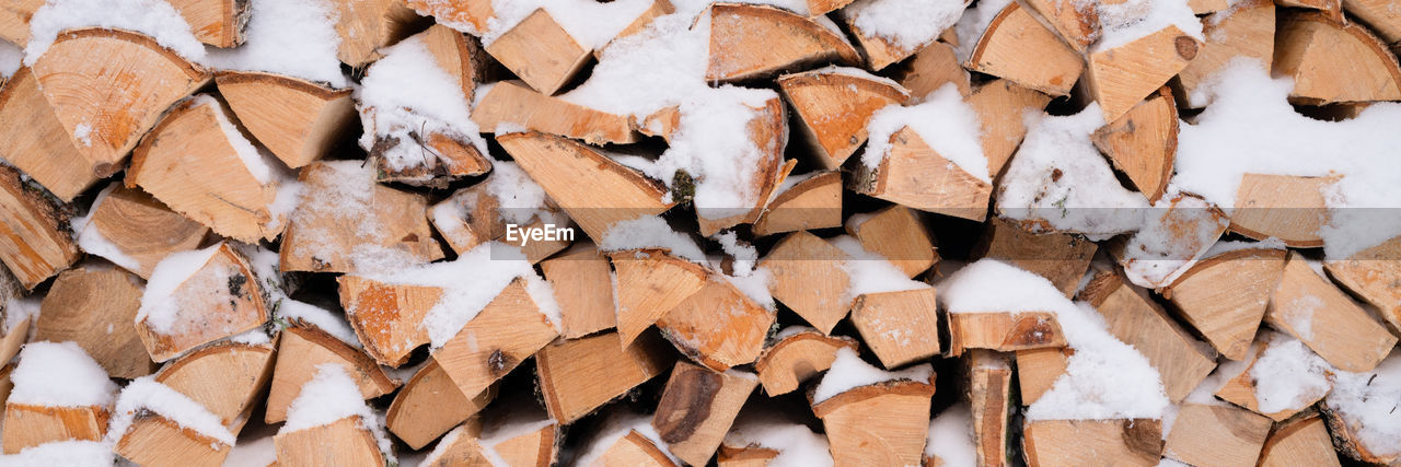 Textured firewood background chopped wood for kindling and heating. woodpile with stacked firewood