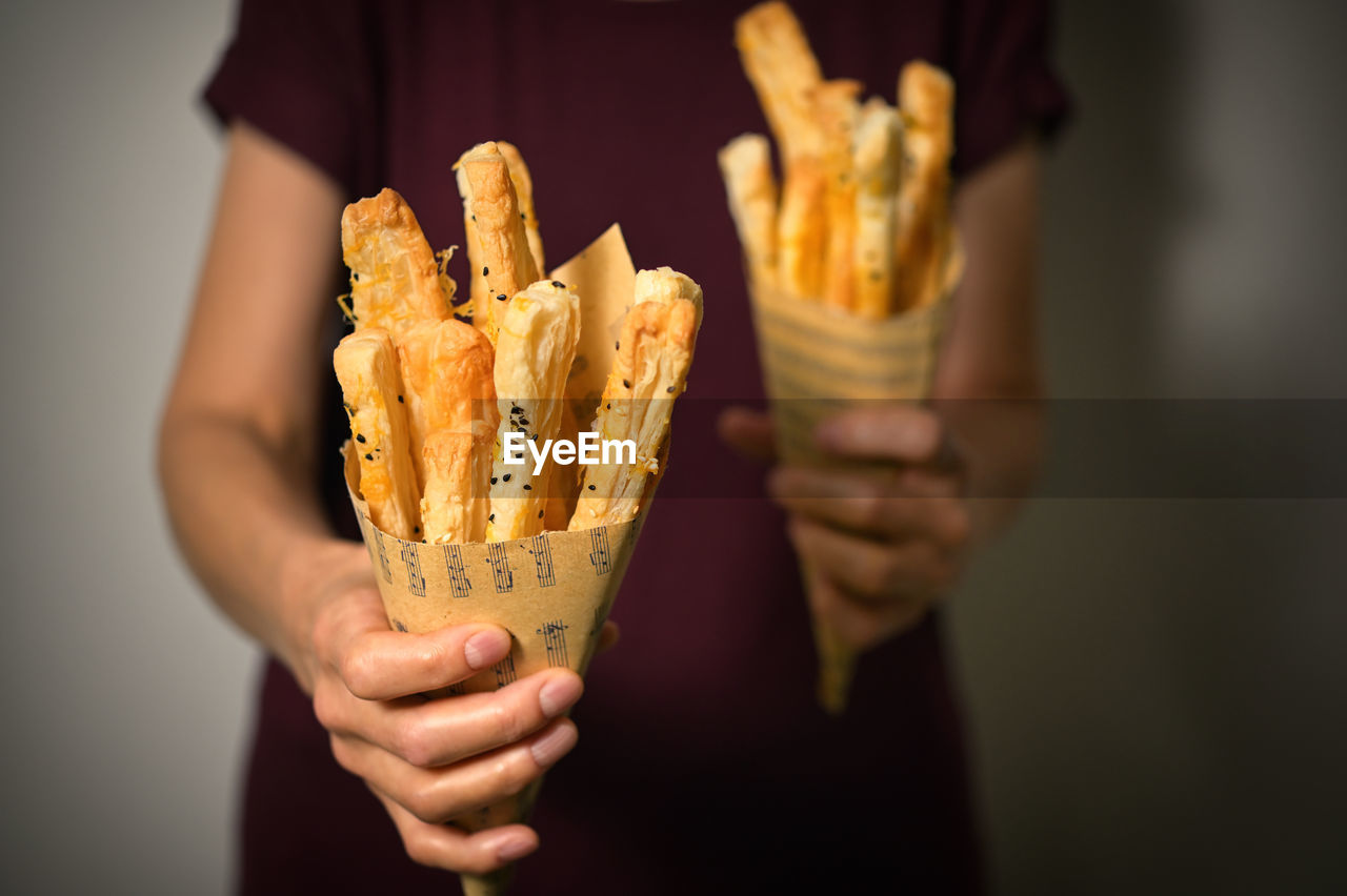 Salted cheese straws and sesame seeds in a paper cone