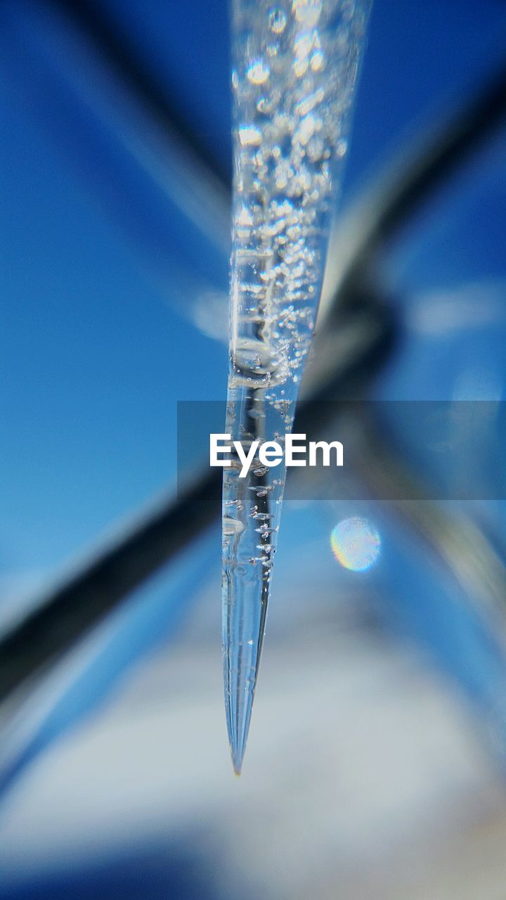 CLOSE-UP OF FROZEN WATER AGAINST BLUE SKY