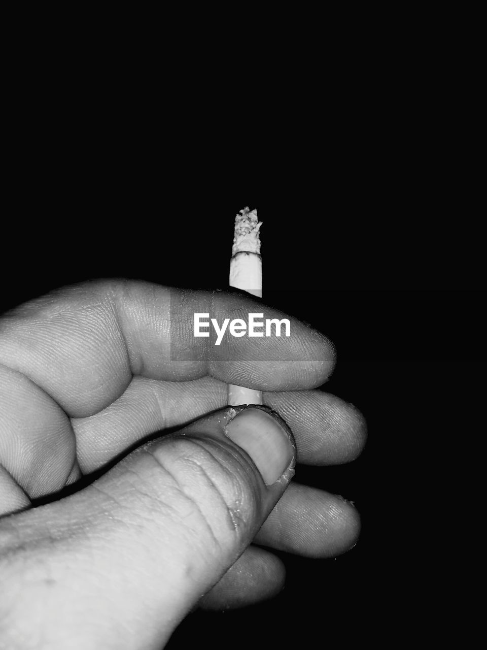 CLOSE-UP OF HUMAN HAND HOLDING CIGARETTE