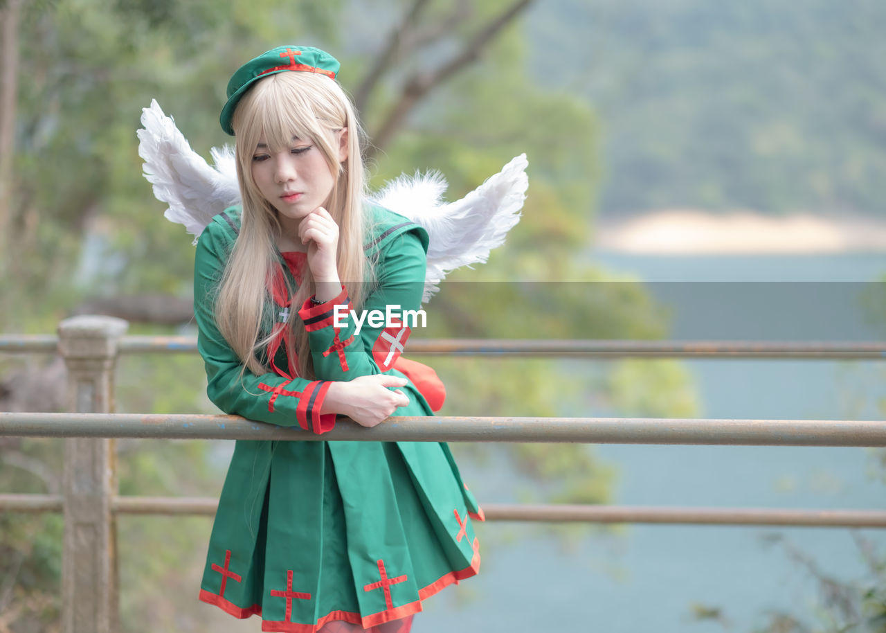 Woman in angel costume leaning on railing